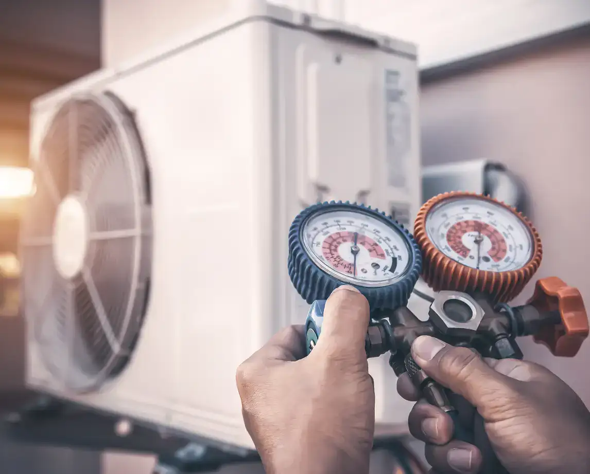 Technician checking refrigerant pressure on a heat pump outdoor unit in Bradenton & Sarasota, FL